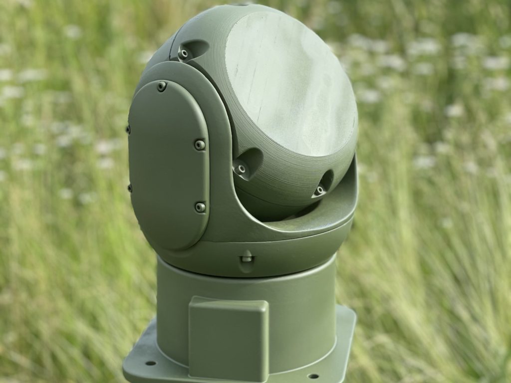 Y3077A radar dome, olive green, in front of a field